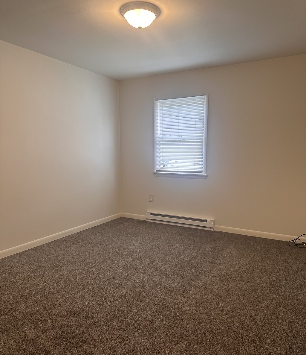 A room with a window and a radiator on the wall.