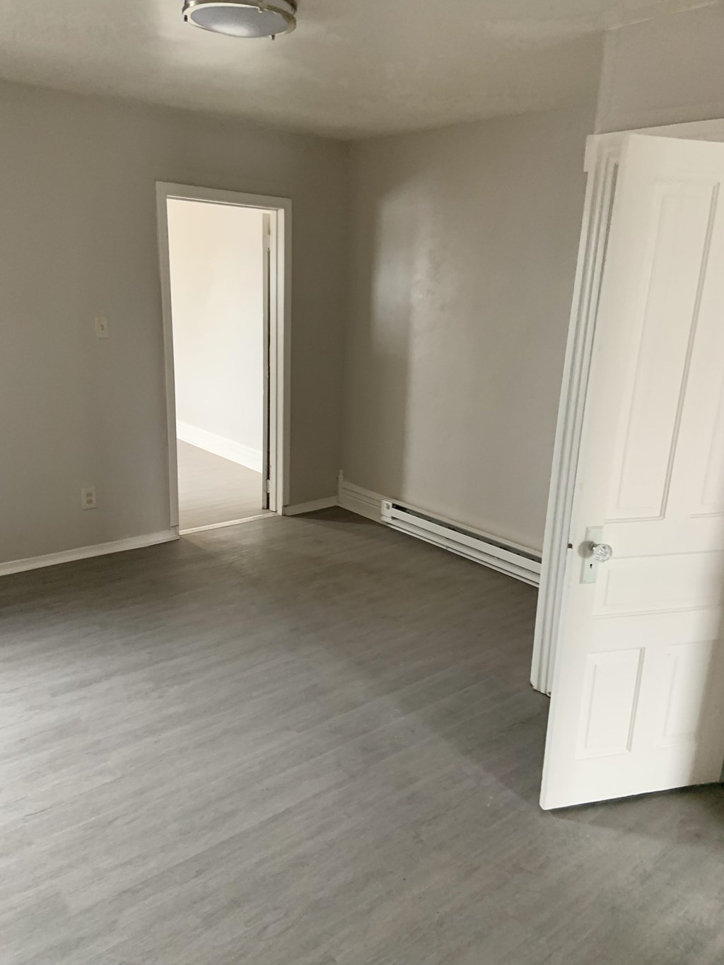 A room with a white door and a white wall.