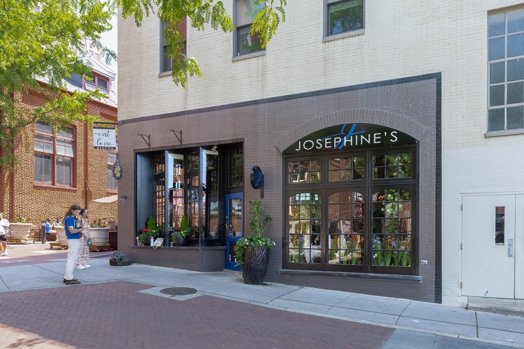 a woman walks past a josephines store on a city street