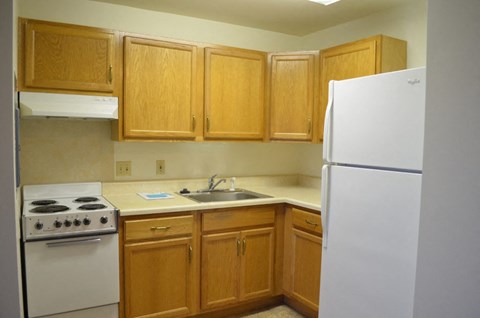 a kitchen with white appliances and wooden cabinets