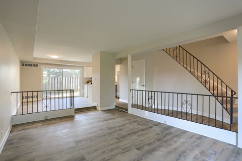 A spacious room with a staircase and a balcony.