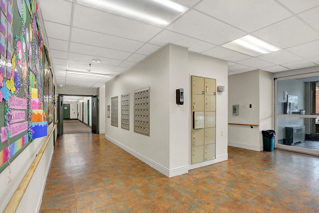 a hallway with lockers and a colorful mural on the wall