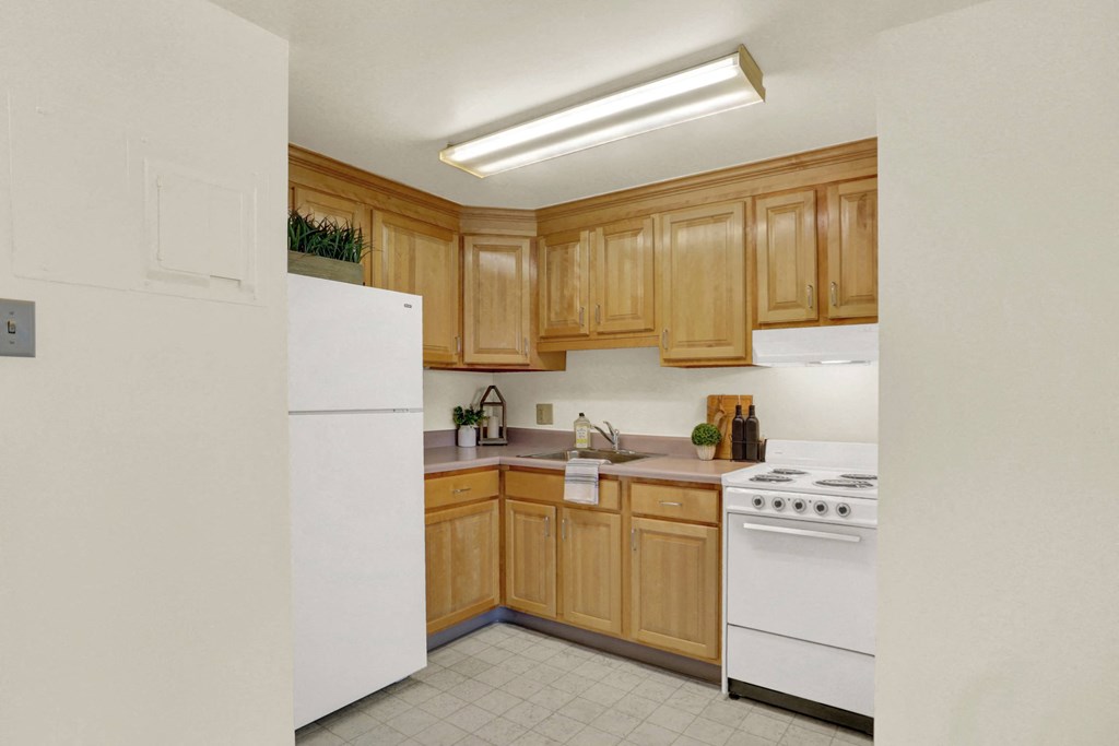 a kitchen with white appliances and wooden cabinets