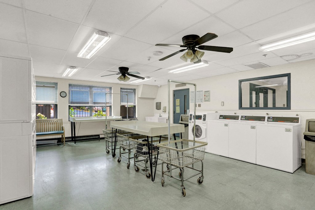 a laundry room with a table and chairs and two ceiling fans