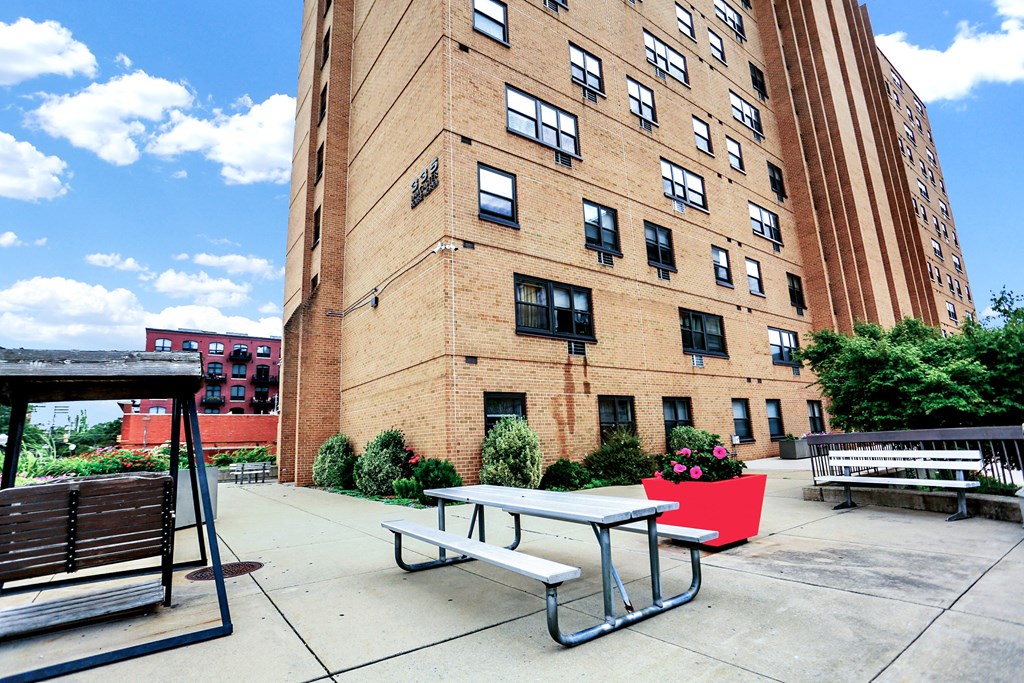 a picnic table sits in front of a brick building