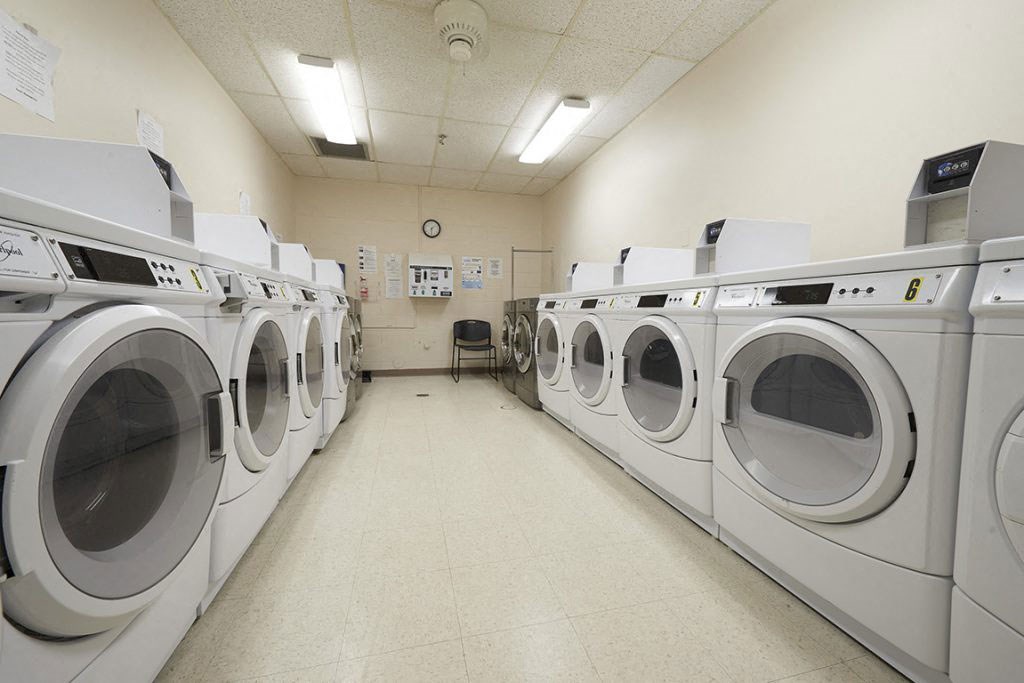 a row of washers and dryers in a laundry room filled with washing machines