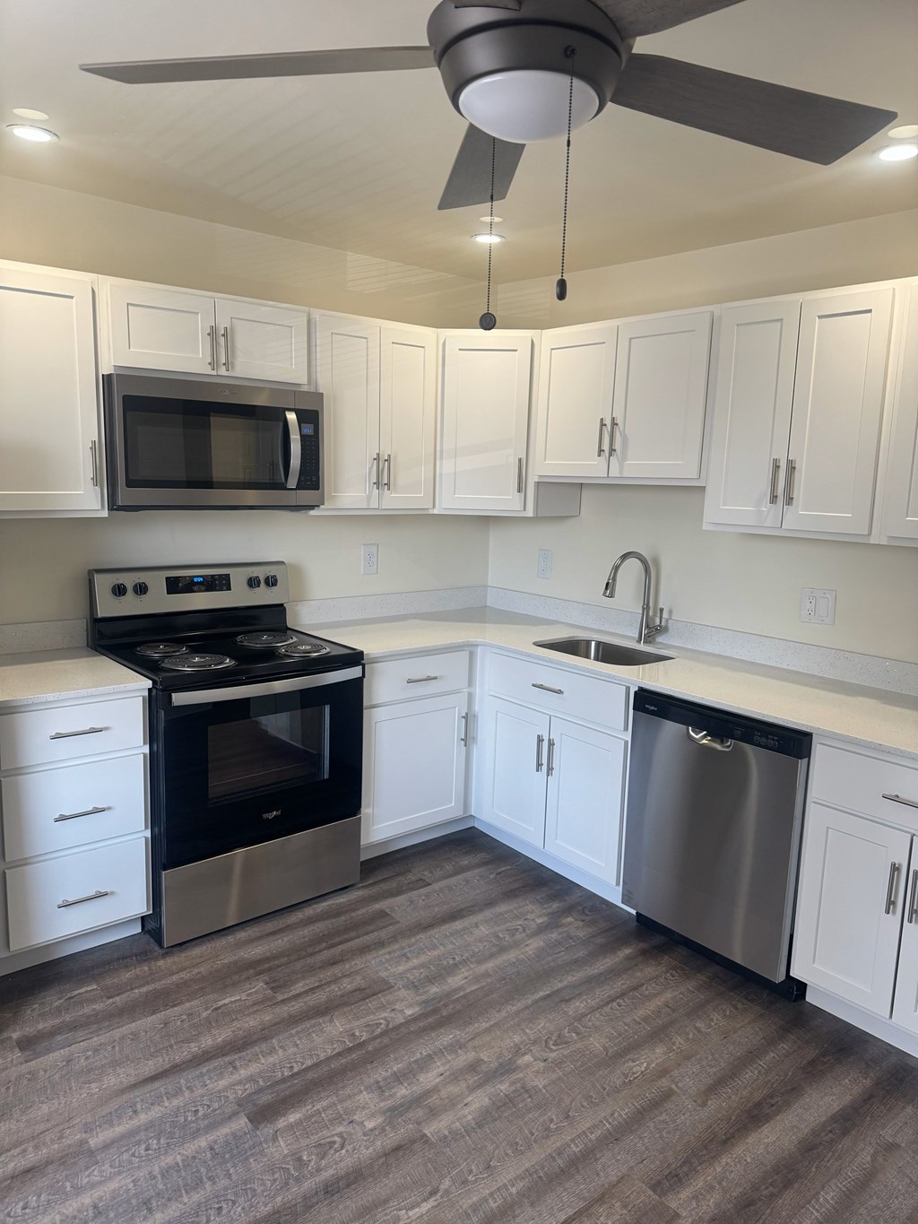 A kitchen with white cabinets and a black stove top oven.