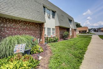 a bench in front of a brick house