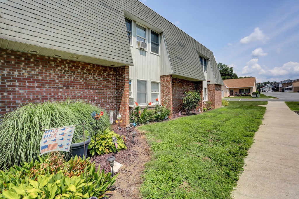 a bench in front of a brick house
