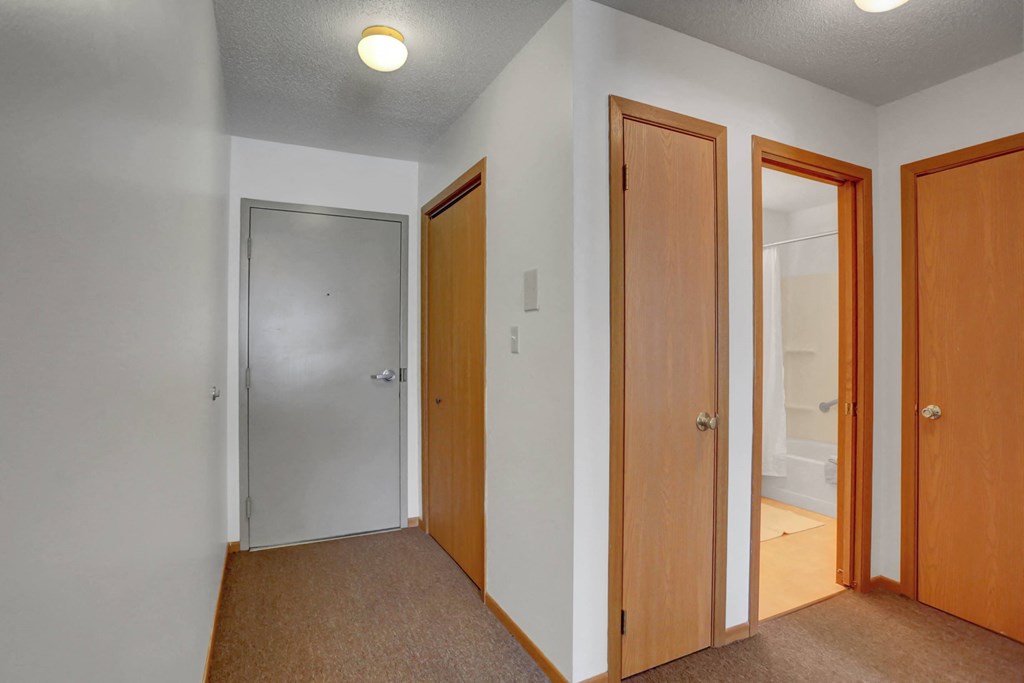 a bedroom with three doors and a carpeted floor