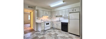 A kitchen with white appliances and cabinets.