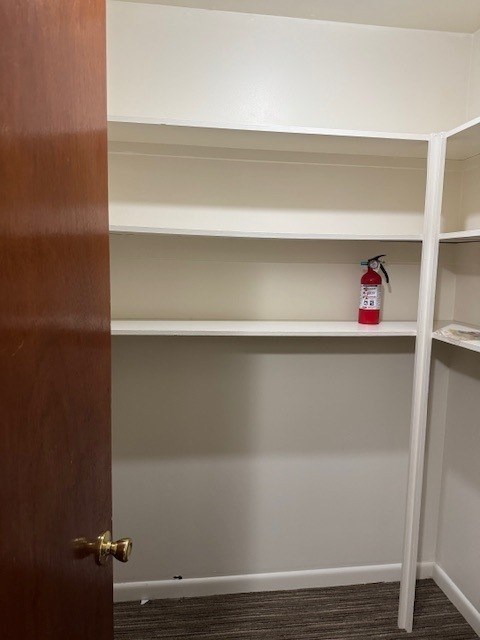 A white shelf with a red fire extinguisher on it.