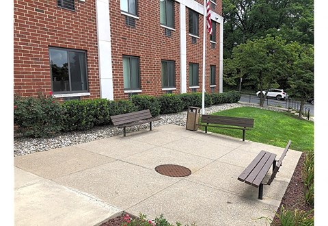 A brick building with a flag on it and a green lawn in front.