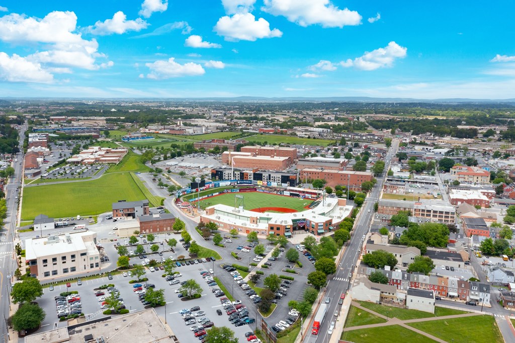 A large stadium is surrounded by buildings in the center of a town.