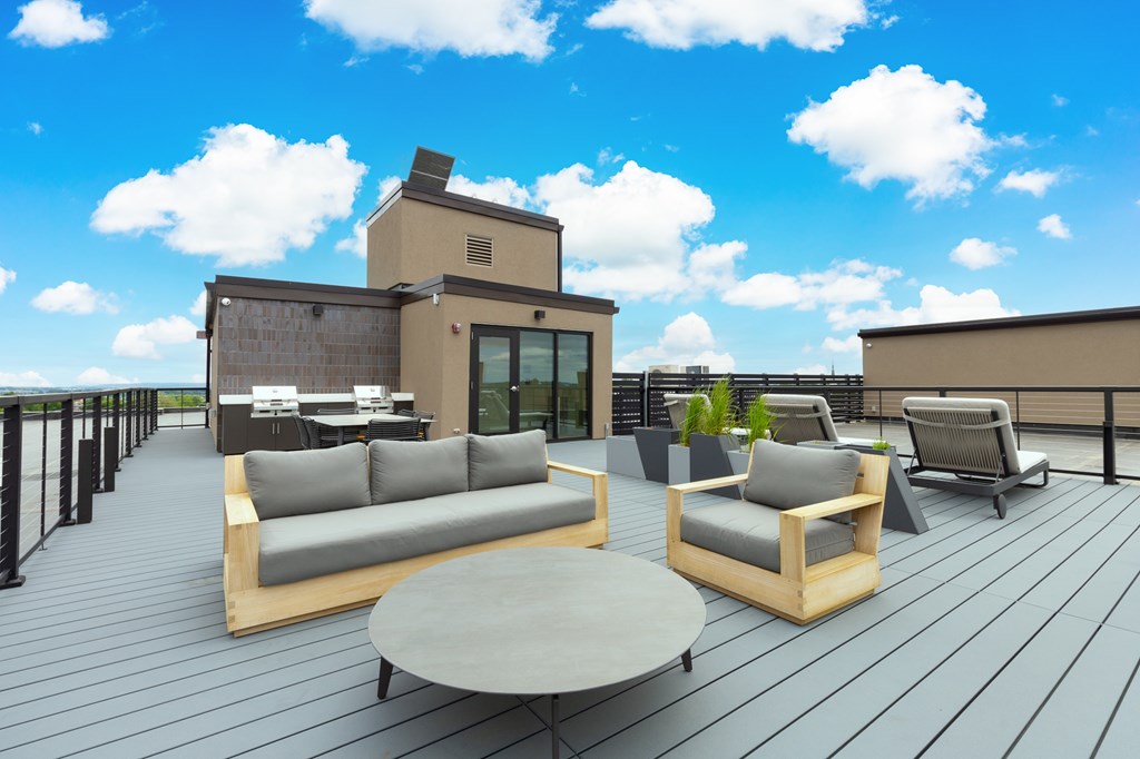 A wooden deck with a table and chairs overlooking a body of water.