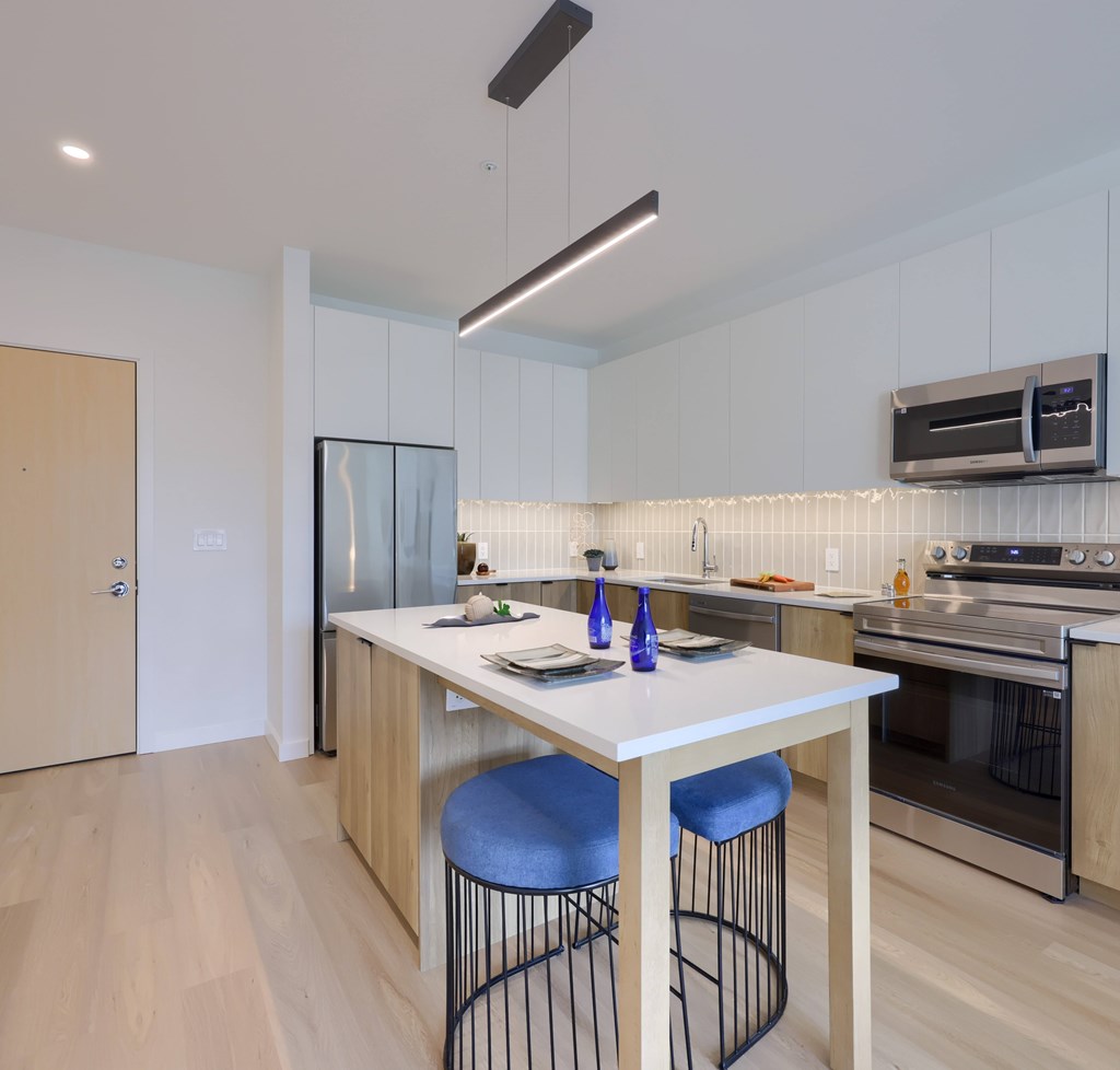 A modern kitchen with a table and chairs.