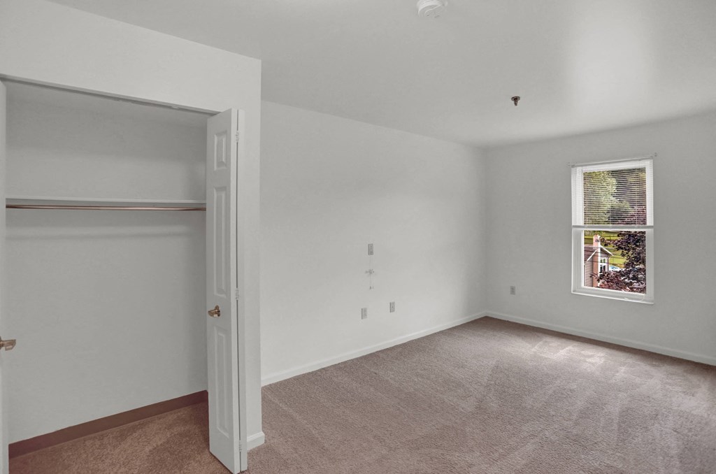 a bedroom with a closet and a window