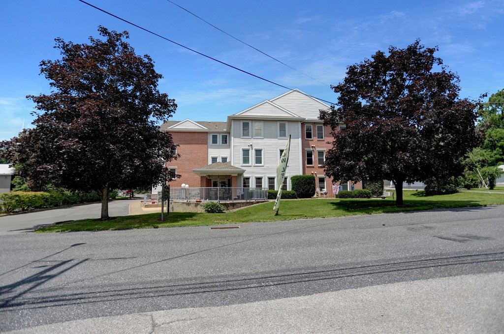Apartments in Three Springs | Three Springs Estates |  a large brick building with a white roof and a street in front of it