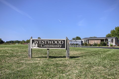 a sign for the westwood community in the middle of a field