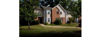 A two-story house with a red brick exterior and a white trim.
