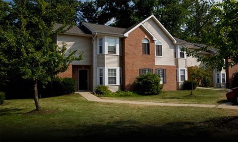 A two-story house with a red brick exterior and a white trim.