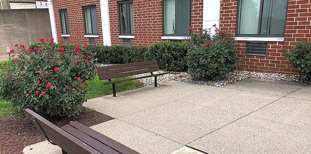 two benches sitting in front of a brick building