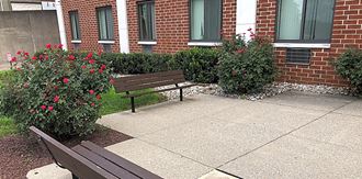two benches sitting in front of a brick building