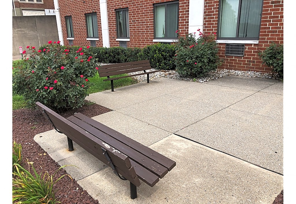 two benches sitting in front of a brick building