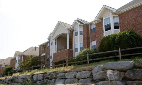 A row of houses with a stone wall in front.