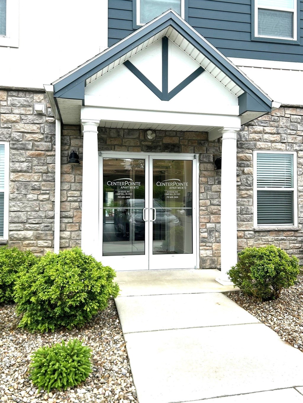 The front of a building with a stone facade and a glass door.