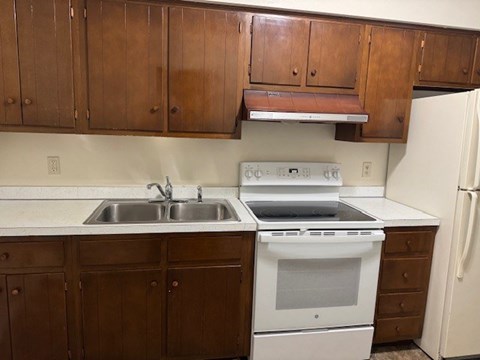 A kitchen with a white stove and sink.