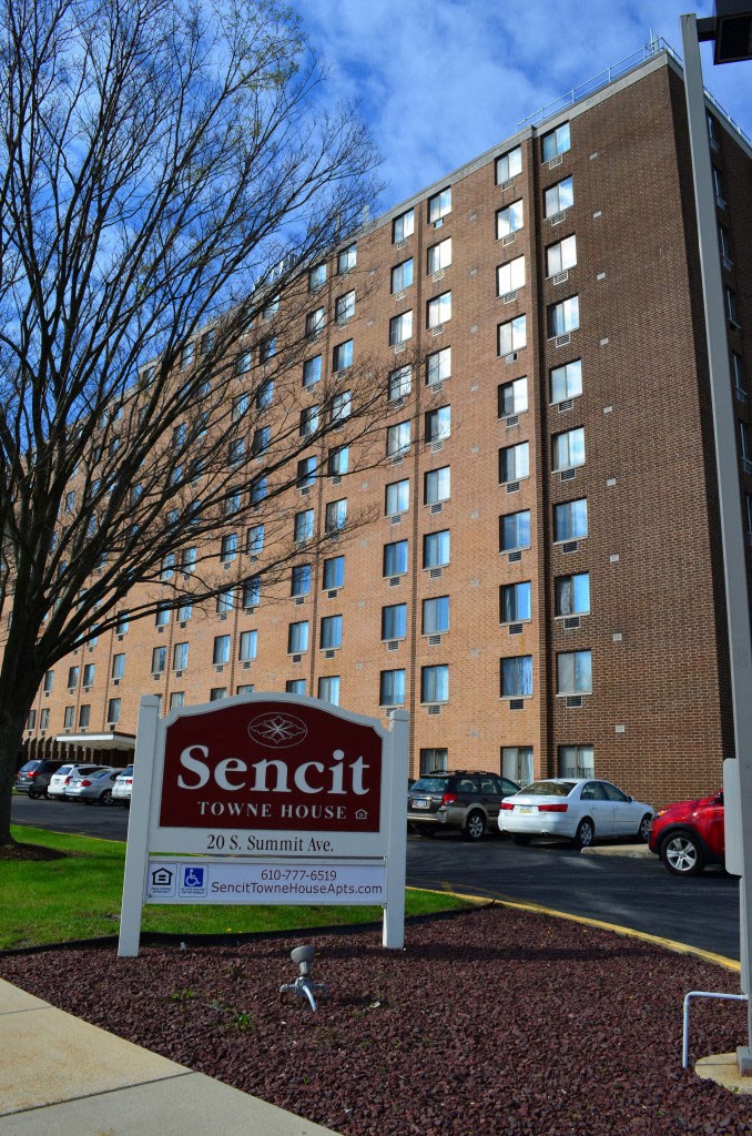 a sign for the sentinel town house in front of a tall building