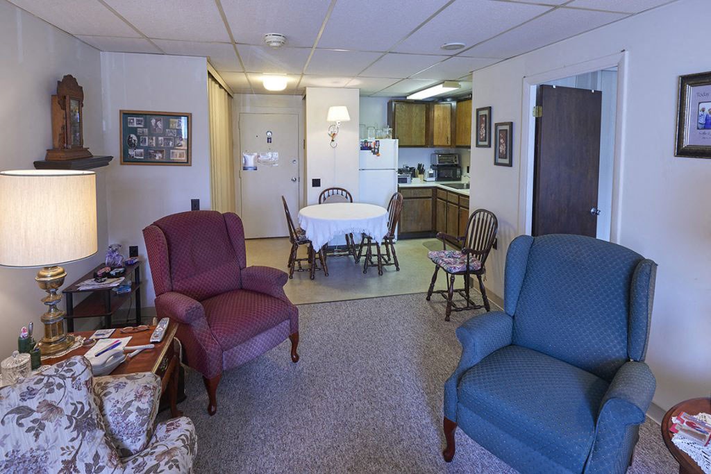 a living room and kitchen with a table and chairs