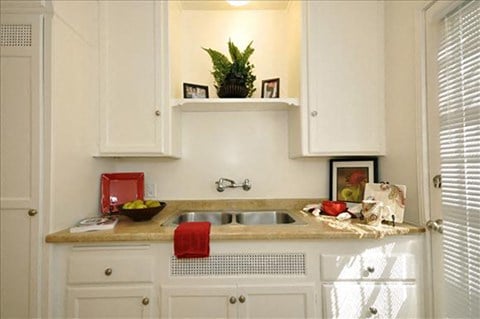 a small kitchen with white cabinets and a sink