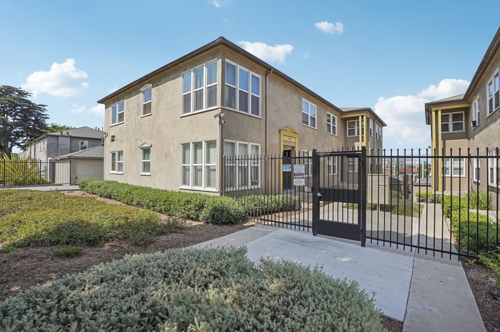 A row of houses with a black gate in front.