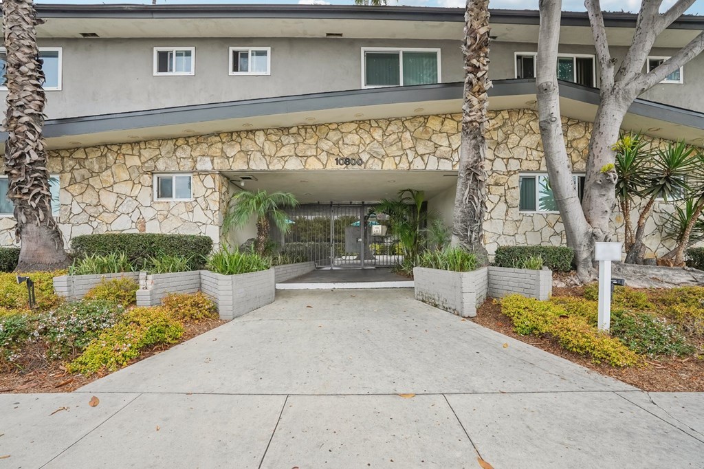 A building with a stone facade and a concrete walkway in front.