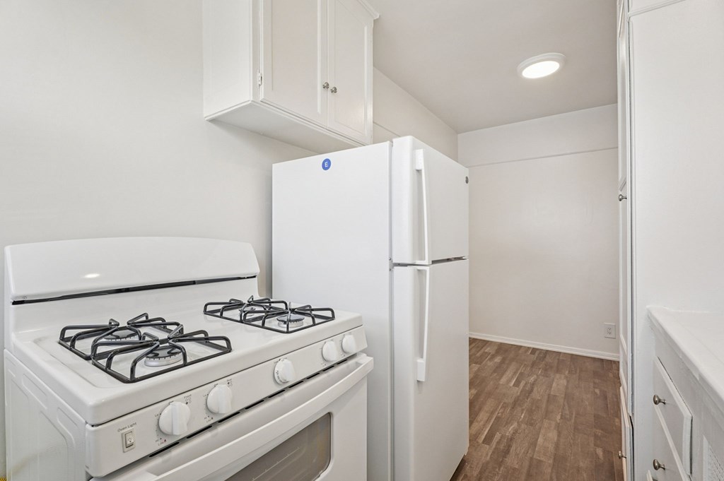 A white gas stove and refrigerator in a kitchen.