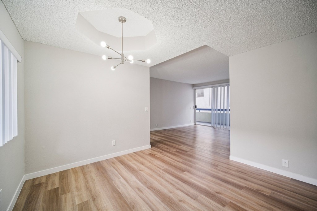A room with wooden floors and a chandelier.