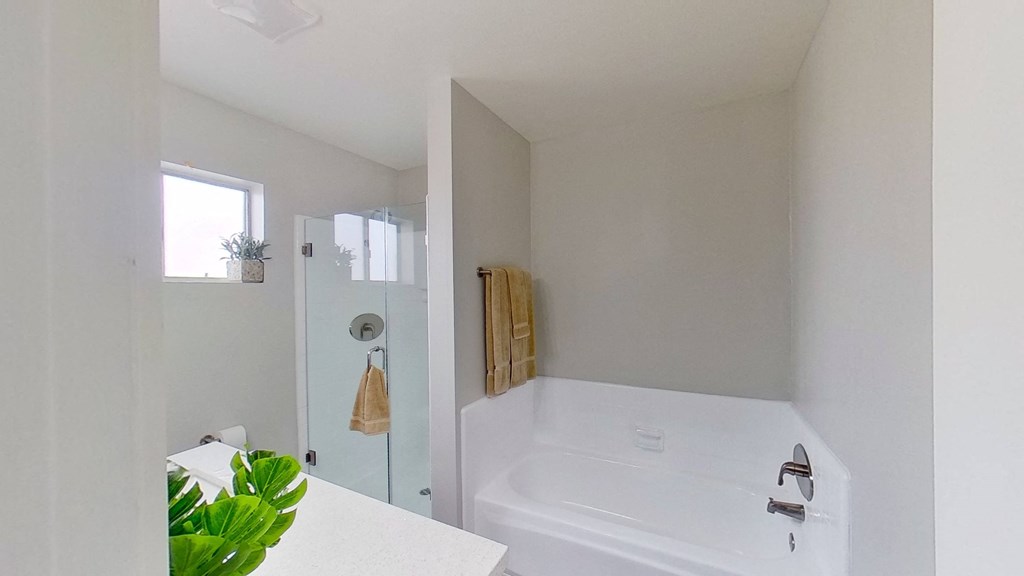 a white bathroom with a large tub and a shower
