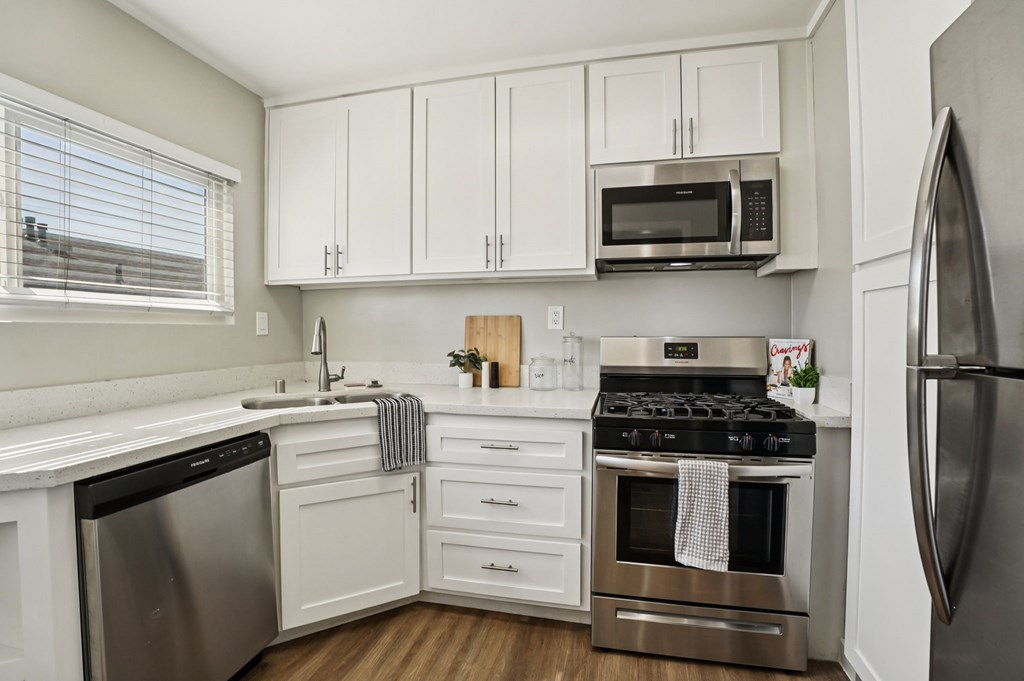 A kitchen with white cabinets and stainless steel appliances.