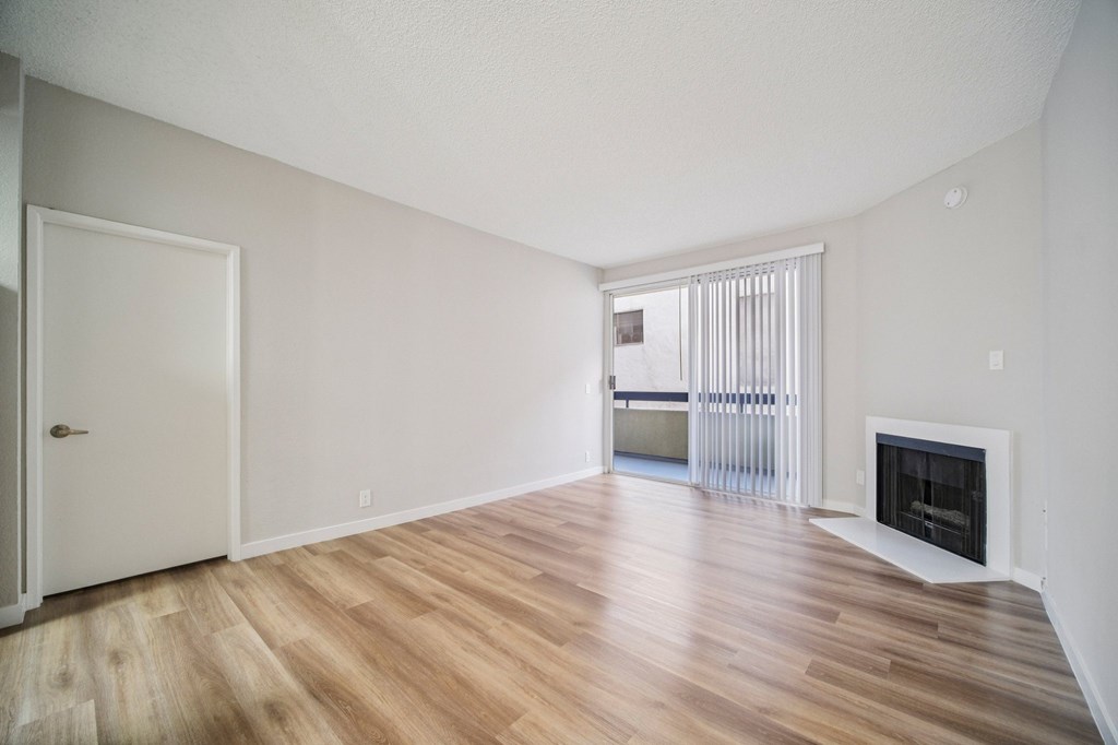A room with a fireplace and a sliding glass door.