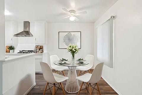 A modern kitchen with a dining table set for four.