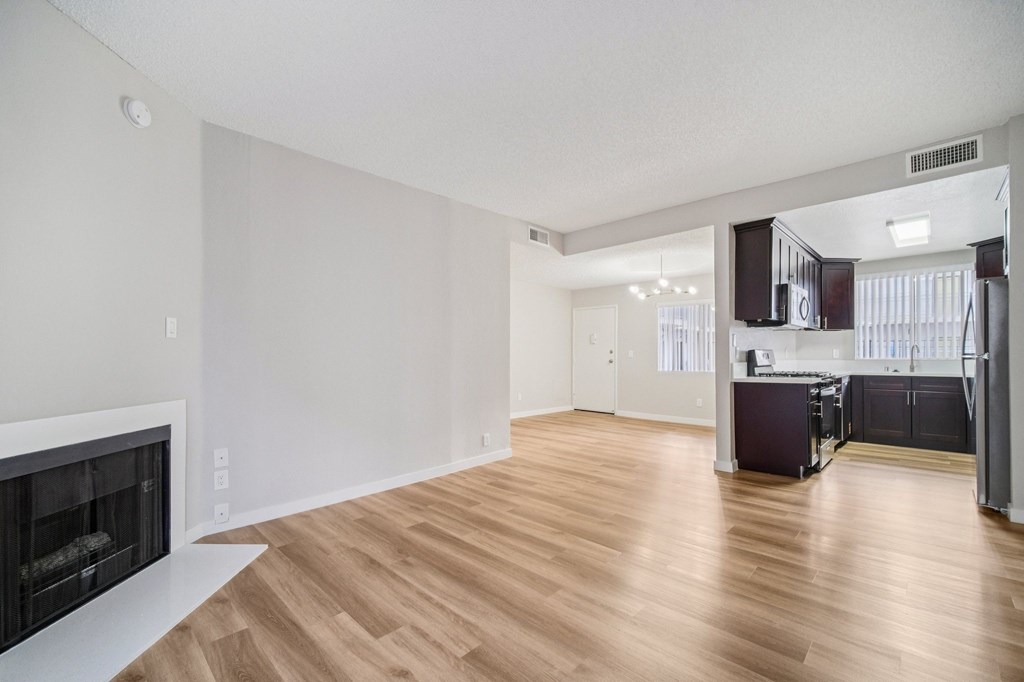A spacious living room with a fireplace and hardwood floors.