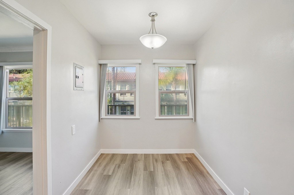 A room with a window and a wooden floor.