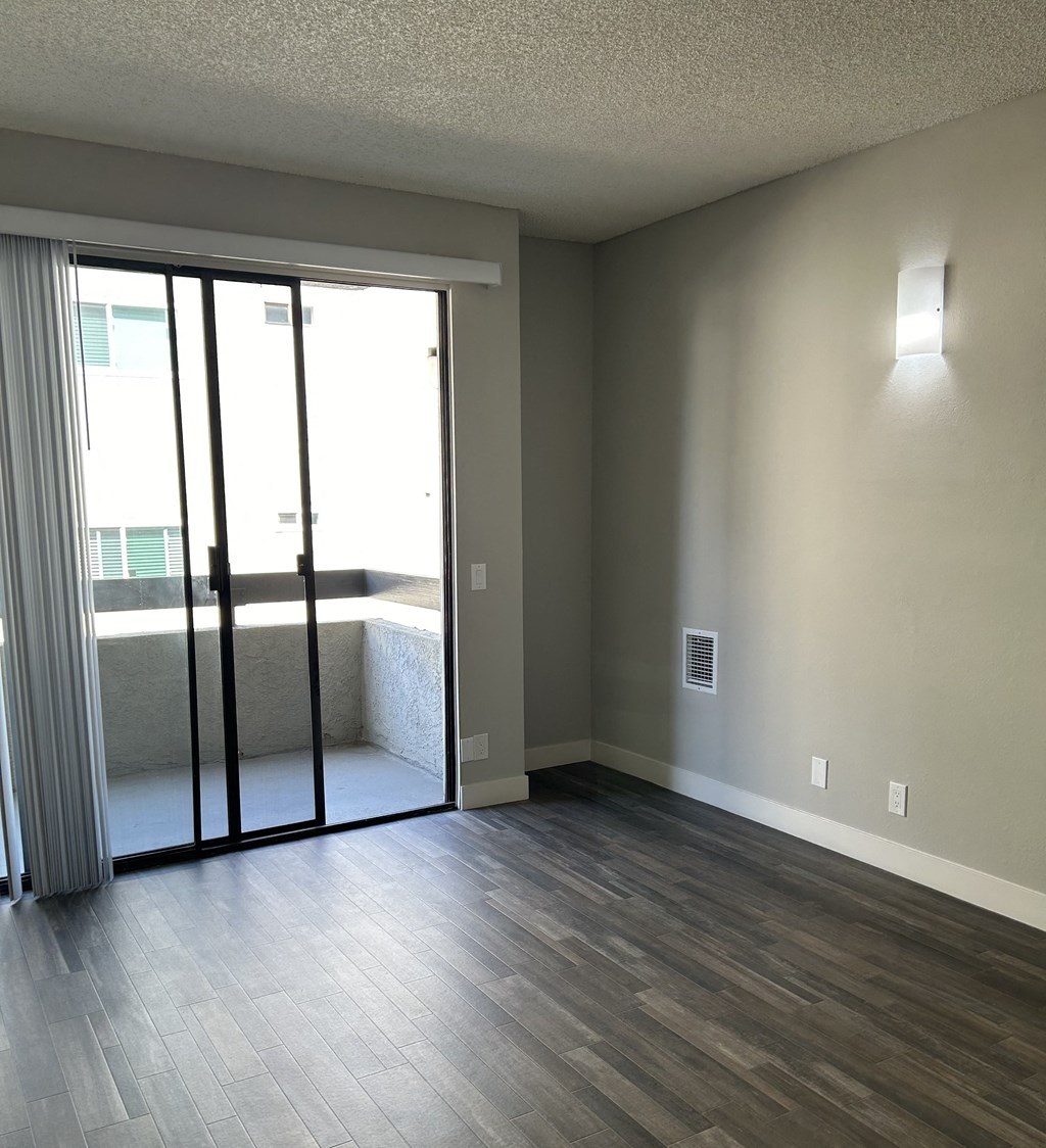 an empty living room with sliding glass doors and a balcony