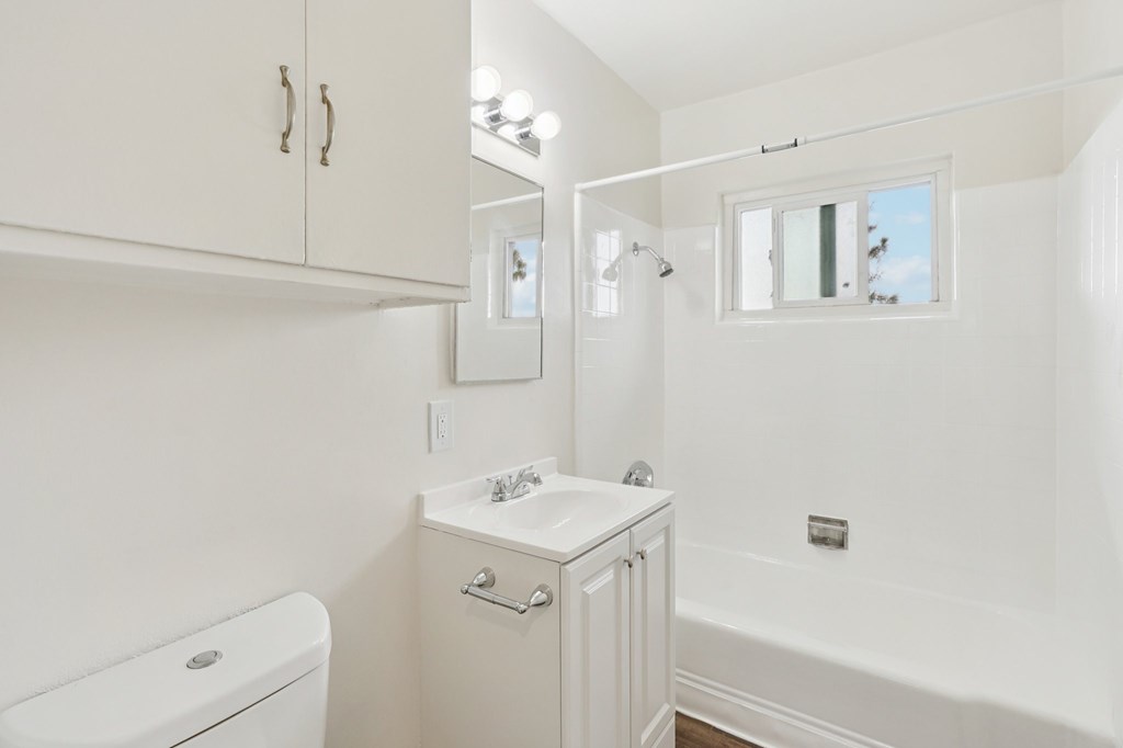 A white bathroom with a toilet, sink, and bathtub.