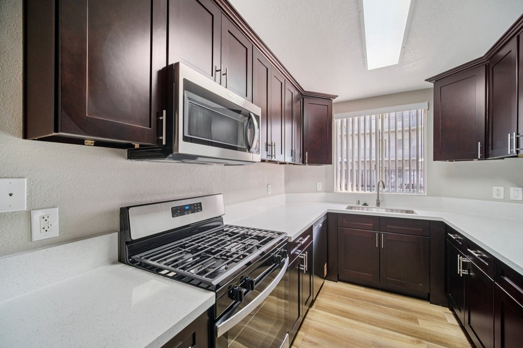 A kitchen with brown cabinets and a white counter top.