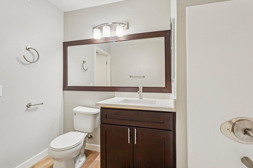 A white toilet sits next to a sink in a small bathroom.