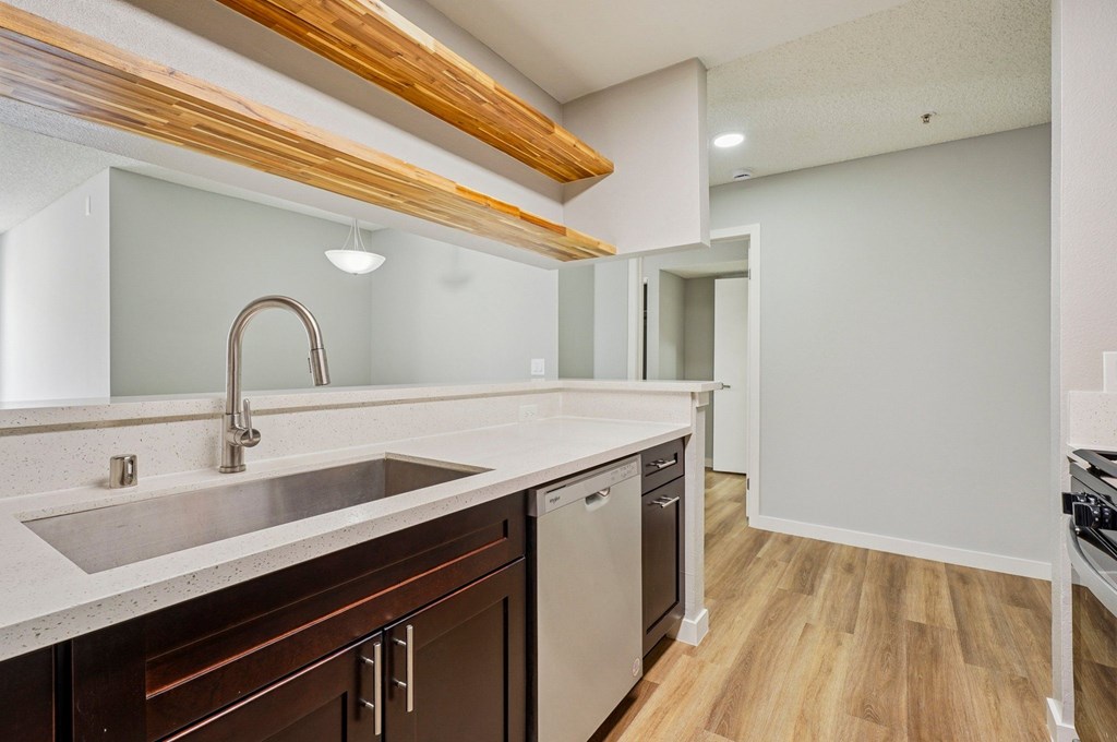 A kitchen with a wooden beam ceiling and a stainless steel sink.