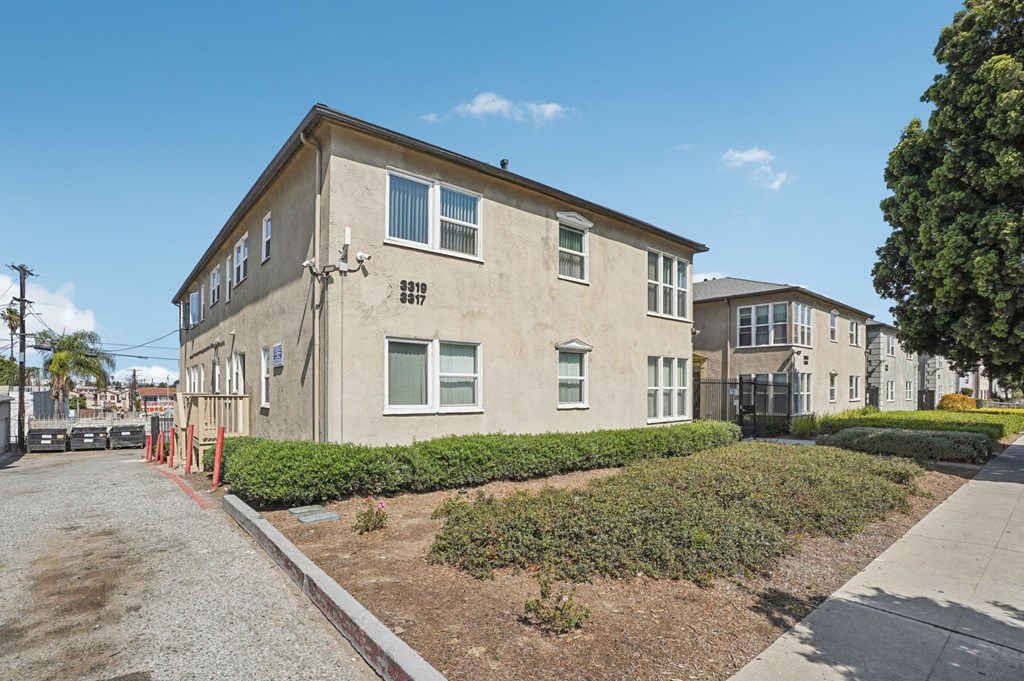 A building with a grey facade and a red line on the sidewalk.